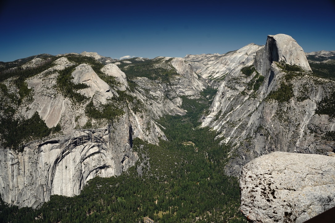 The whole of Yosemite valley from Glacier Point, Half Dome on the right and a granite ledge in the foreground