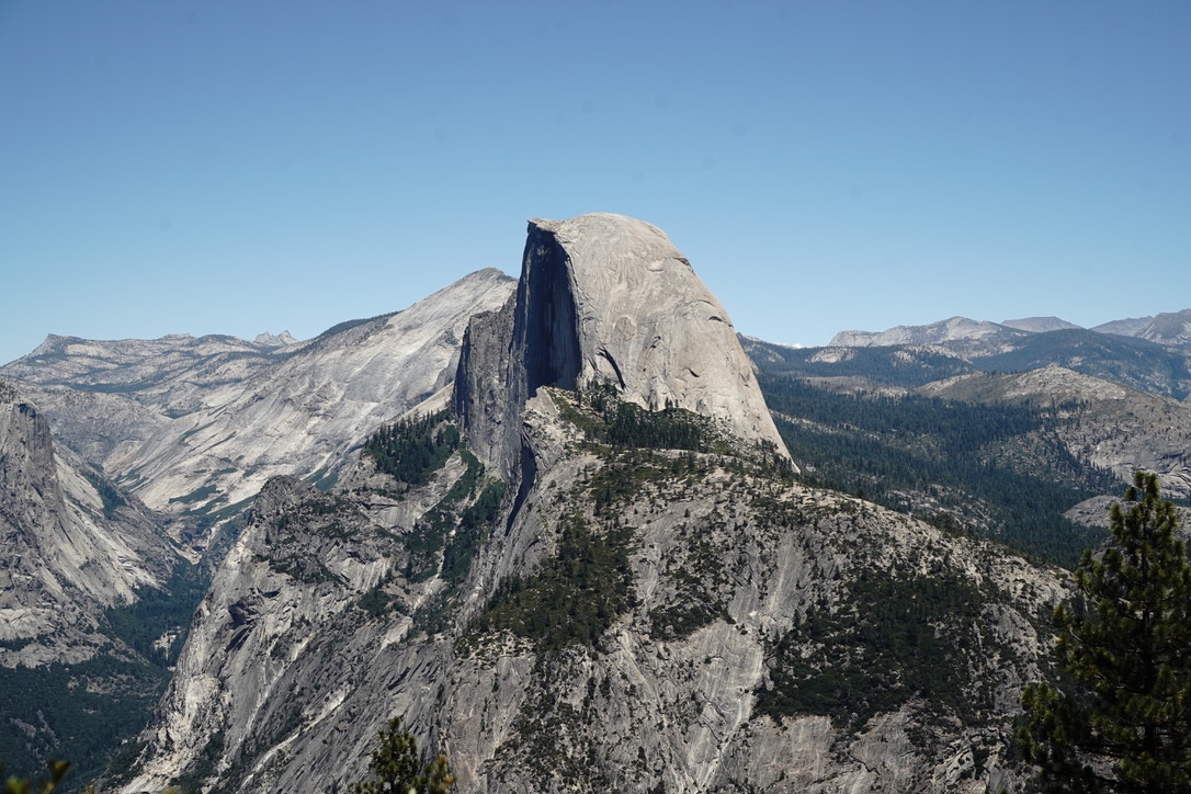 Half Dome from Glacier Point, its sheer face in shadow against a pale sky