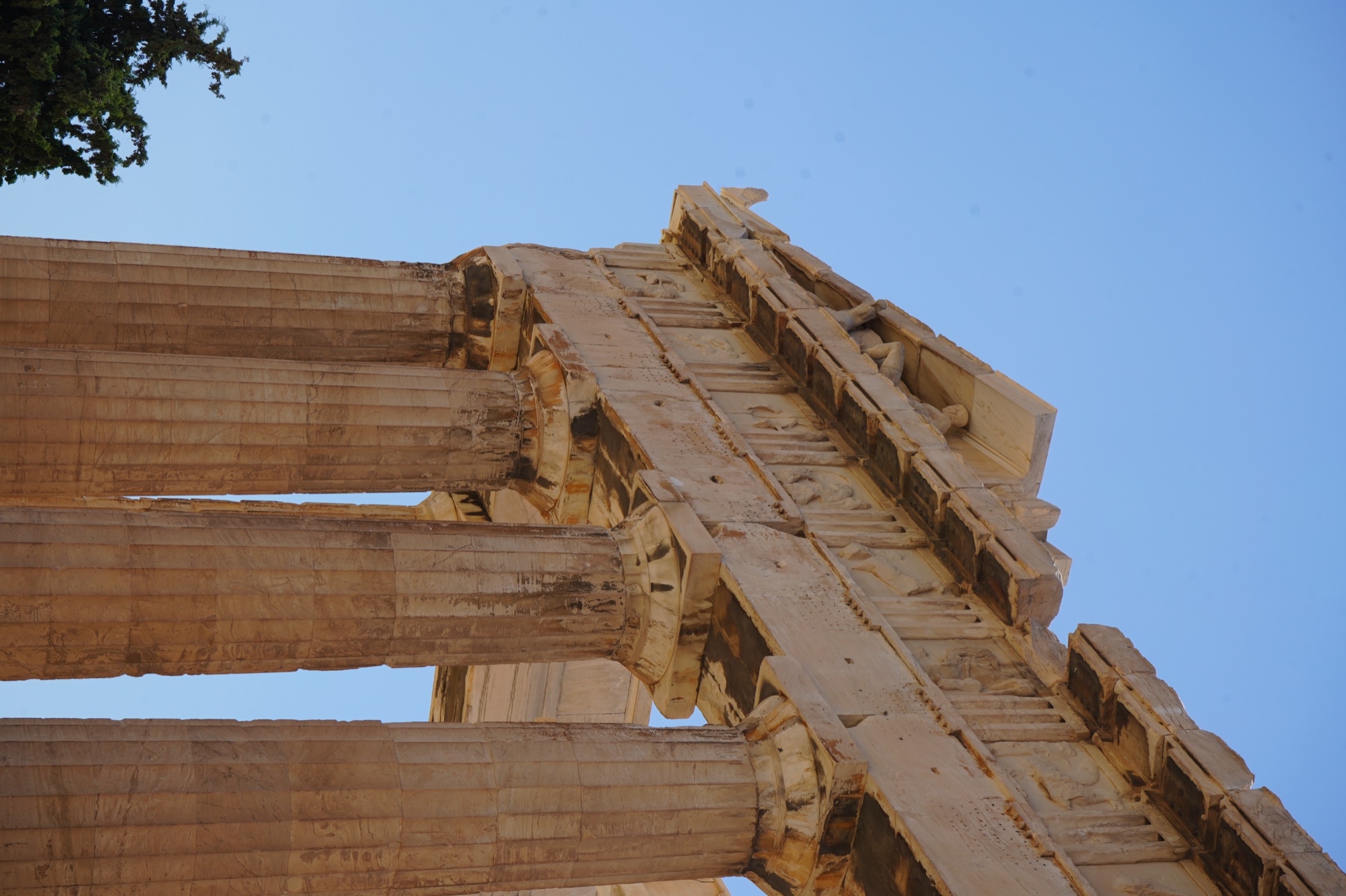 The corner of the Parthenon: pediment figures, frieze and columns stacked against the blue